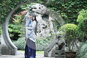 Chinese woman in traditional Blue and white Hanfu dress Standing in the middle of beautiful gate