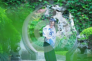 Chinese woman in traditional Blue and white Hanfu dress Standing in the middle of beautiful gate