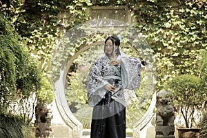 Chinese woman in traditional Blue and white Hanfu dress Standing in the middle of beautiful gate