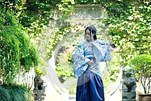 Chinese woman in traditional Blue and white Hanfu dress Standing in the middle of beautiful gate