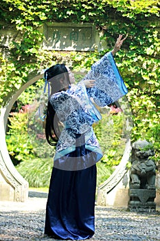 Chinese woman in traditional Blue and white Hanfu dress Standing in the middle of beautiful gate