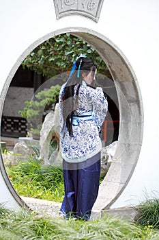 Chinese woman in traditional Blue and white Hanfu dress Standing in the middle gate