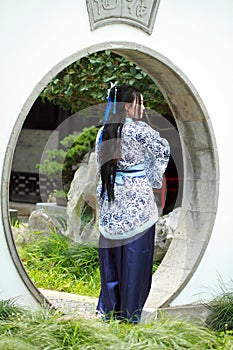 Chinese woman in traditional Blue and white Hanfu dress Standing in the middle gate