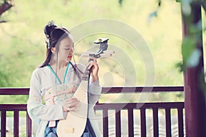 Chinese woman in traditional Hanfu dress,play traditional instrument of pipa