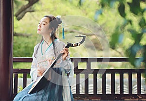 Chinese woman in traditional Hanfu dress,play traditional instrument of pipa