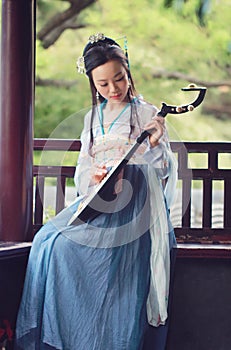 Chinese woman in traditional Hanfu dress,play traditional instrument of pipa