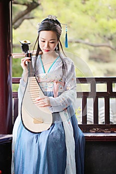 Chinese woman in traditional Hanfu dress,play traditional instrument of pipa
