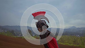 A Chinese woman in war costume walking desperately on the mountain with brown soil in the background