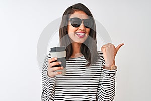 Chinese woman wearing sunglasses drinking take away coffee over isolated white background pointing and showing with thumb up to