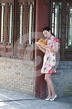 A Chinese woman wears Cheongsam in the water park of Shanghai