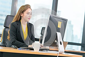 Chinese woman working with computer laptop in modern city office