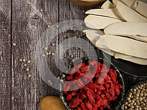 The Chinese yam or san yao and goji berry on wood table for food concept