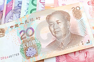 Chinese Yuan banknote over a rainbow of international banknotes