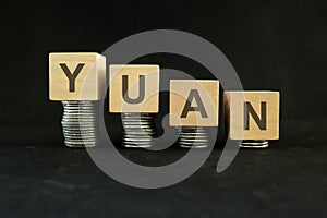 Chinese yuan currency weakening, value depreciation and devaluation concept. Decreasing stack of coins
