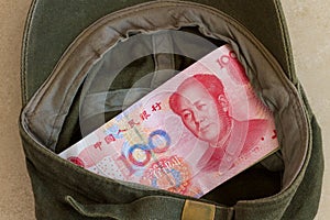 Chinese yuan or renminbi as donations in a cap.