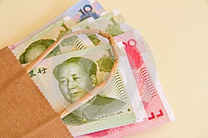 Chinese Yuan renminbi notes in a brown paper bag.