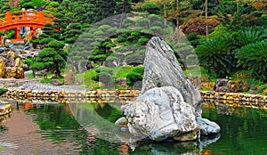 Chinese zen garden with red bridge and rocks