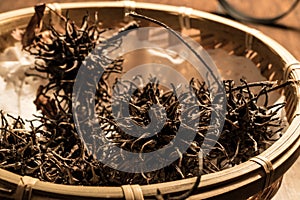 Chinesse Tea Da Hong Pao or Conifer Cone in a wooden basket.