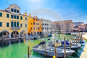 Chioggia cityscape with narrow water canal Vena with moored multicolored boats