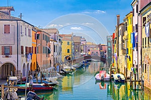 Chioggia cityscape with narrow water canal Vena with moored multicolored boats photo