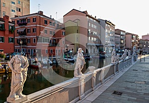 Chioggia - Collection of ancient statues graces peaceful water canal in the charming town of Chioggia