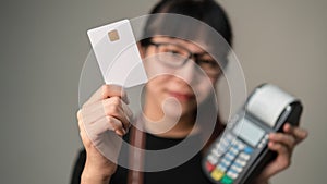 Chip card holding by asian woman in blurry with post terminal or EDC for payment, Concept of contactless card for new way of