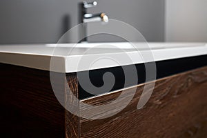 Chipboard CPD particle board particleboard LDSP under basin cabinet corner and table top closeup. Bathroom interior photo