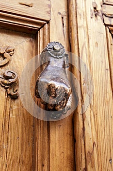 Chipped doorknocker with hand shape on wooden door