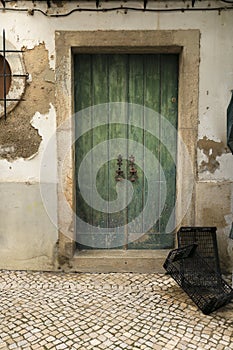 Chipped facade with old green wooden door