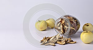 Chips apples in a glass jar and pieces of this fruits on a white background, horizontal format, Copy space