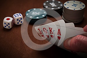 Chips and cards for poker in hand on table