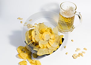 Mug of light beer, with crispy potato chips and peanuts, on a white background. food for a quick snack to beer.