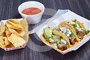 Chips red salsa street taco meal 3 corn tortilla lengua cow beef tongue Mexican lime wedge photo