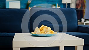 Chips snack sitting on coffe table in front of cozy sofa