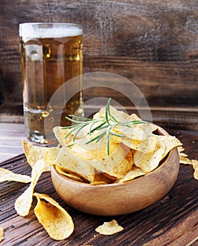 Chips in a wooden bowl and beer