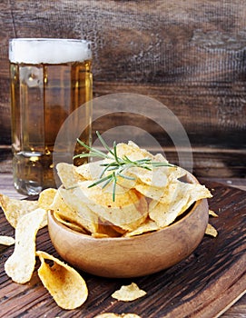 Chips in a wooden bowl and beer
