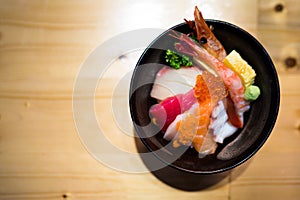 Chirashi sushi, Japanese food rice bowl with raw salmon sashimi, mixed seafood, top view, darken edge