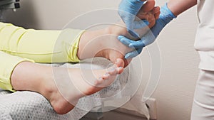 Chiropodist massages the client's feet. Closeup. The concept of chiropody, pedicure and podology