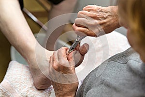 Chiropodist with a nail scissors photo