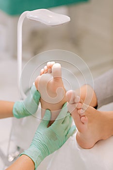 Chiropodist using lamp while practicing acupressure for woman