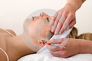 Chiropractor applying ear acupuncture techniques. photo