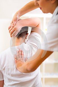 Chiropractor doing adjustment on male patient. Selective focus