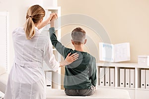 Chiropractor examining child with back pain