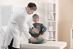 Chiropractor examining child with back pain