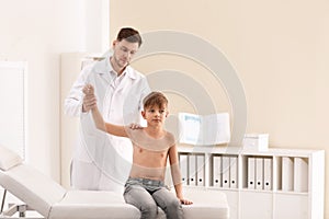 Chiropractor examining child with back pain