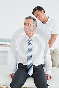 Chiropractor examining mature man
