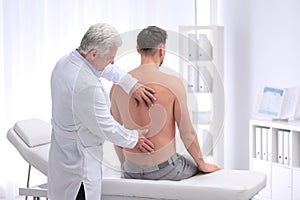 Chiropractor examining patient with back pain