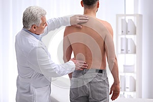 Chiropractor examining patient with back pain