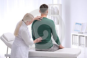 Chiropractor examining patient with back pain