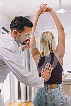 Chiropractor treating a woman as a patient in his office